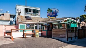 A beachside restaurant with a sign reading 'Pixie Deli & Good Eats.'