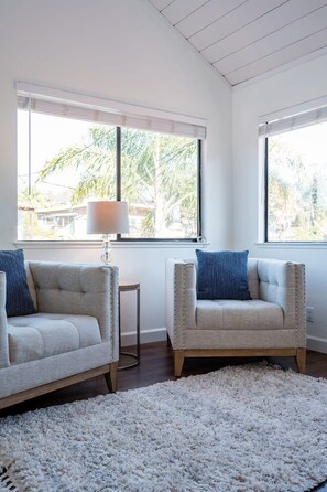 A modern living room with two sofas, a small side table, and a fluffy rug. - Amazing Beach House w/ Jacuzzi and Fire Pit (Aptos)
