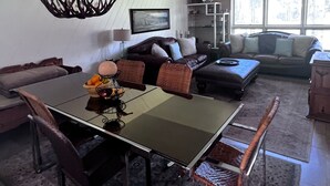 A dining area with a glass table and chairs, a chandelier, and a sofa in the background. - Welcoming & Comfortable Townhome Great Multi-Level Layout (Eagle Vail)