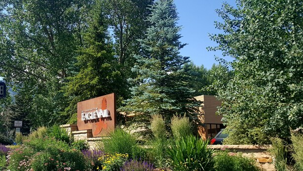 A sign for the University of Eagle Valley surrounded by a landscaped garden with various plants and flowers. - Welcoming & Comfortable Townhome Great Multi-Level Layout (Eagle Vail)