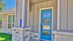 A house with a blue door, stone pillars, and a mailbox.