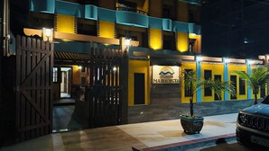 A hotel entrance with a gated driveway, a sign reading "Pousada Maravista," and a parked car. - Pousada Maravista (Anchieta)
