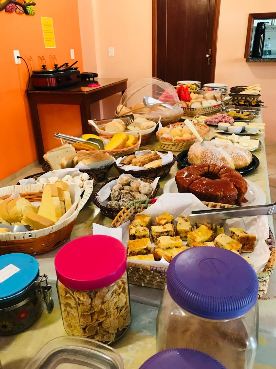 Een buffet met diverse gerechten, waaronder brood, gebak en desserts.