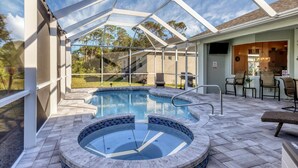A covered outdoor swimming pool with a glass roof, a hot tub, and a patio area with seating. - NewToVRBO RELAX- Own Home Private Pool, Hot Tub, near Beaches, Golf & Pickleball (Rotonda West)
