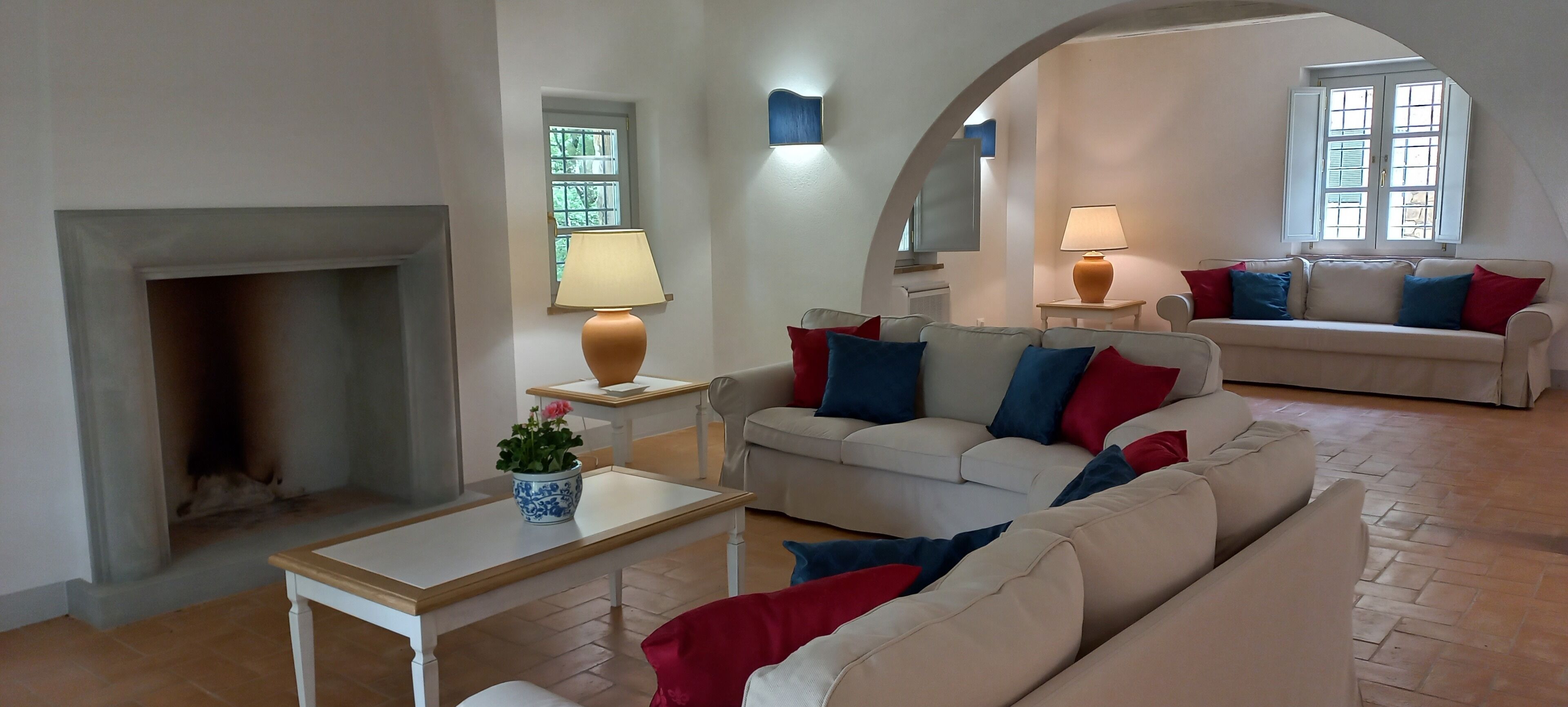 Uma sala de estar com lareira, dois sofás, uma mesa de centro e uma televisão.