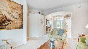 A spacious living room with a large map on the wall, a wooden coffee table, and a green sofa.