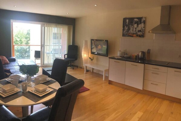 Un appartement moderne doté d’un coin repas, d’une cuisine et d’un balcon avec vue.