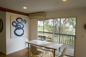 Enjoy a peaceful meal or meeting in this serene space with a view of the lush outdoor area.