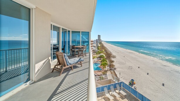 Un balcon avec vue sur une plage et l’océan.