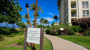 Une pancarte accueillant les visiteurs du Westin Resort Villas, avec un chemin menant à un bâtiment entouré de verdure et de palmiers.