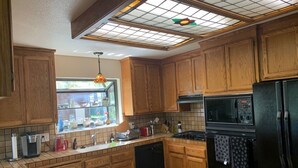 Una cocina con armarios de madera, un refrigerador negro, un microondas y un lavavajillas.