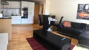 Un appartement moderne comprenant une cuisine, un coin repas et un salon.
