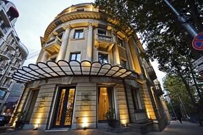 A historic building with a grand entrance, a balcony, and a plaque indicating it is a hotel. - Astoria Tbilisi (Tbilisi)
