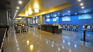 A hotel lobby with a reception desk, seating area, and a large window with blinds. - Astoria Tbilisi (Tbilisi)