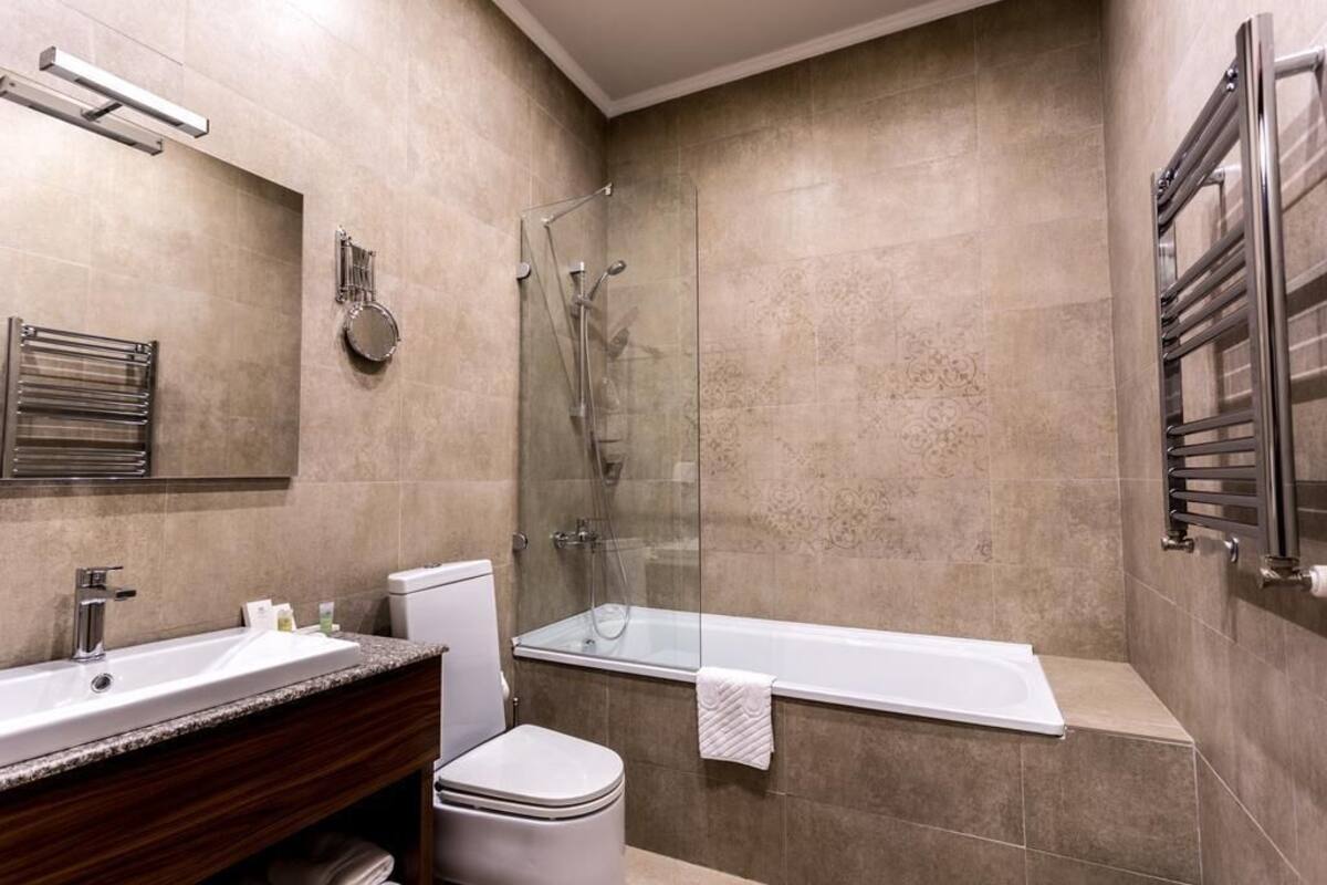Ein modernes Badezimmer mit einer Duschkabine, einer Badewanne, einer Toilette und einem Waschtisch.