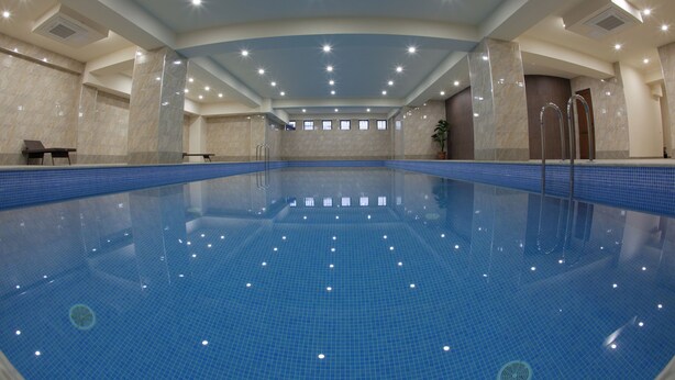 A large indoor swimming pool with clear blue water, surrounded by walls with a marble finish. - Astoria Tbilisi (Tbilisi)