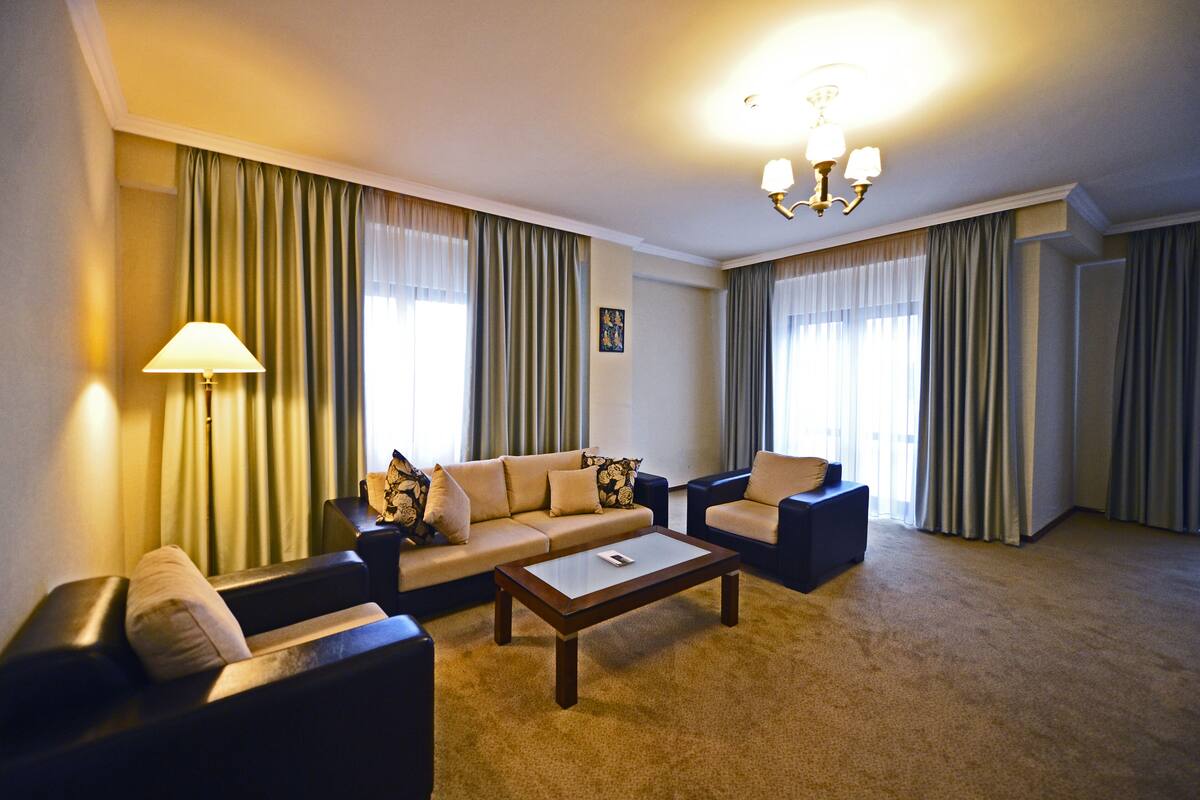 Ein Hotelzimmer mit einer Sofagarnitur, einem Couchtisch und einer Lampe.
