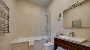 A modern bathroom with a bathtub, toilet, and sink. - Astoria Tbilisi (Tbilisi)