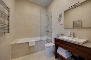 A modern bathroom with a bathtub, toilet, and sink. - Astoria Tbilisi (Tbilisi)
