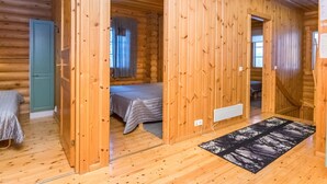 A log cabin interior with a bed, a door, and a window. - Karhunpesä a by Interhome (Puolanka)