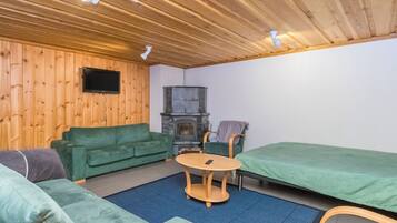 A cozy room with a green sofa, a small round table, and a bed.