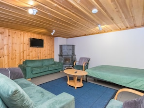 Una habitación acogedora con un sofá verde, una mesita redonda y una cama.