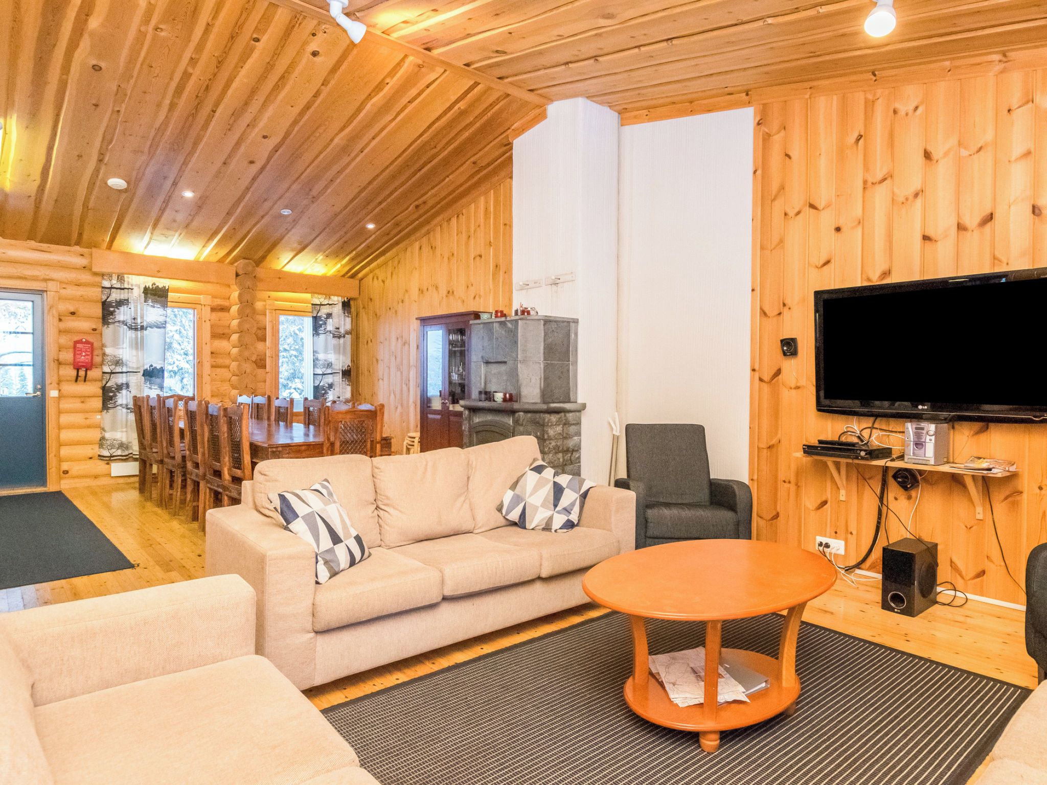 L'intérieur d'un chalet confortable, avec un canapé, un téléviseur et un coin repas.