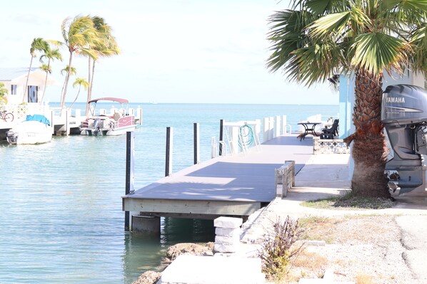 Relax by the tranquil waterfront, where a dock offers a space for dining or relaxation, and a nearby building provides comfortable accommodations.