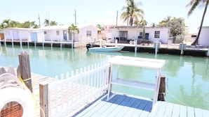 A dock with a lifebuoy, a small boat, and a white fence. - Oceanside, Pet Friendly, Smart Home with-SUP, kayak with and 60 ft Dock (Marathon)
