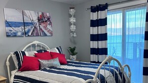 Ein Schlafzimmer mit einem Bett, einem Nachttisch, einer Topfpflanze, einer Wandleuchte und einem Fenster mit Vorhängen.