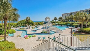 Um resort com uma ampla área de piscina, palmeiras e um gazebo.