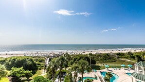 Um resort com piscina, acesso à praia e vista para o oceano.