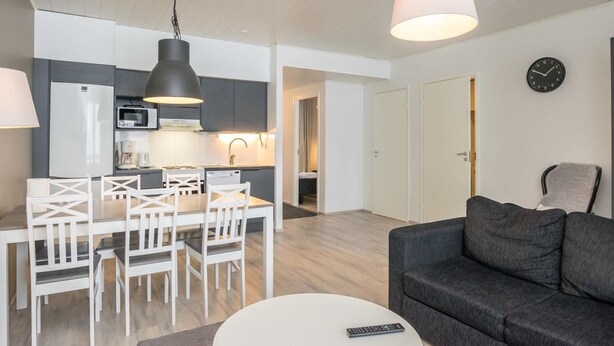 A modern apartment with a dining area, kitchen, and living room. - Skivillas paljakka 6. (2mh) by Interhome (Puolanka)