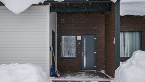 A snow-covered entrance to a building with a door marked with the number 6. - Skivillas paljakka 6. (2mh) by Interhome (Puolanka)