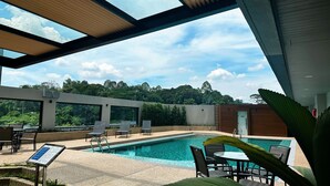 A modern outdoor pool area with lounge chairs and a clear view of the surrounding greenery. - IDEAS Kuala Lumpur (Kuala Lumpur)