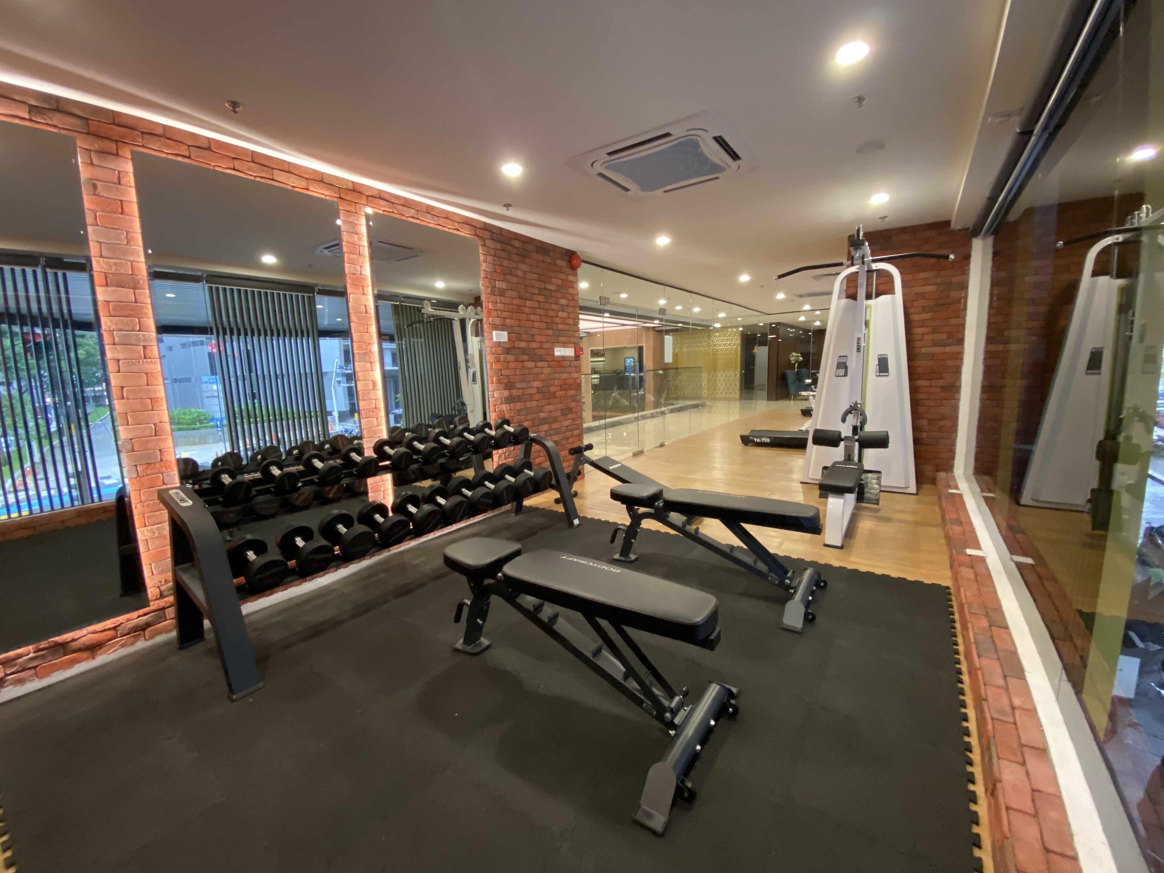 A gym with weight benches, dumbbells, and exercise machines.