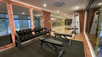 A gym with weight benches, dumbbells, and exercise machines.