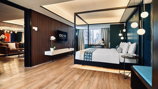 A modern hotel room with a large bed, a TV, a desk, and a view of the city. - IDEAS Kuala Lumpur (Kuala Lumpur)