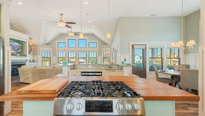 Una cocina amplia con una isla central, estufa integrada y ventilador de techo.
