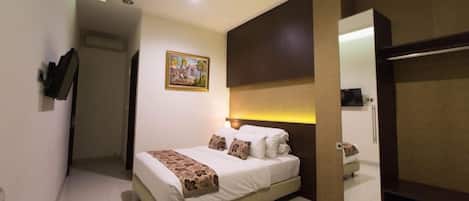 Una habitación de hotel con una cama, una mesita de noche, un espejo y una puerta que da a otra habitación.