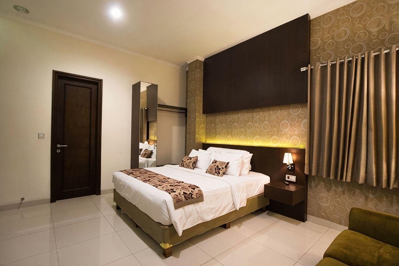Une chambre à coucher avec un lit, une table de chevet, des rideaux et une porte.