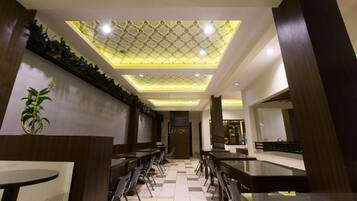 A modern interior with a central seating area, a patterned ceiling, and a visible door labeled 'AMORY'.