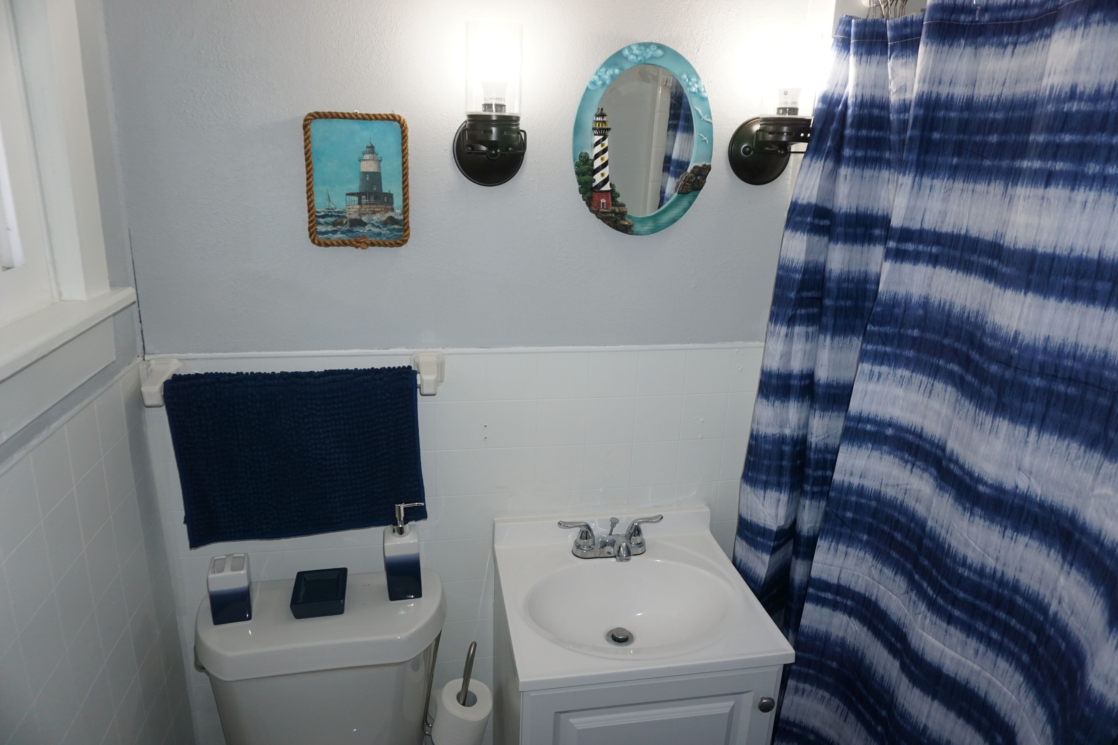 A bathroom with a toilet, sink, and two wall-mounted mirrors.