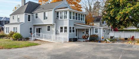 A two-story house with a porch, a garage, and a driveway.