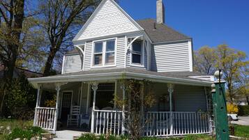 A two-story house with a porch and a chimney.