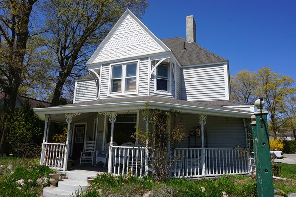 A two-story house with a porch and a chimney.