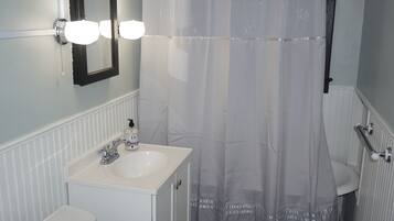 A bathroom with a white sink, a mirror, and a shower curtain.