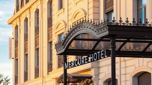 A hotel entrance with a sign reading 'Mercure Hotel' and a wrought iron canopy. - Mercure Tashkent South (Tashkent)