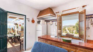 Une cuisine compacte avec vue, un coin repas doté de sièges extérieurs et une grande fenêtre.
