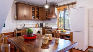Eine Küche mit Holzausstattung, einer Mikrowelle, einer Waschmaschine und einem Kühlschrank.
